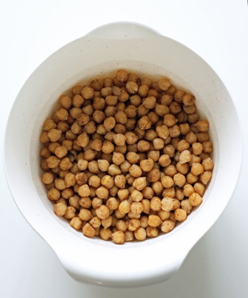 Pyörittele kypsiä kikherneitä kulhossa niin, että ne ovat kauttaaltaa mausteiden peitossa.