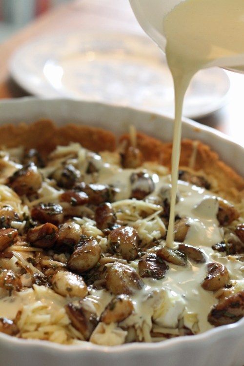 Kaada kermojen ja kananmunien seos juustojen ja valkosipulien päälle.